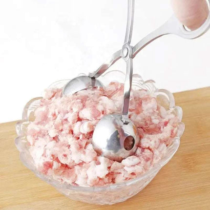 Close-up of a bowl filled with ground meat, and a pair of silver-colored meatball tongs are immersed in the meat.