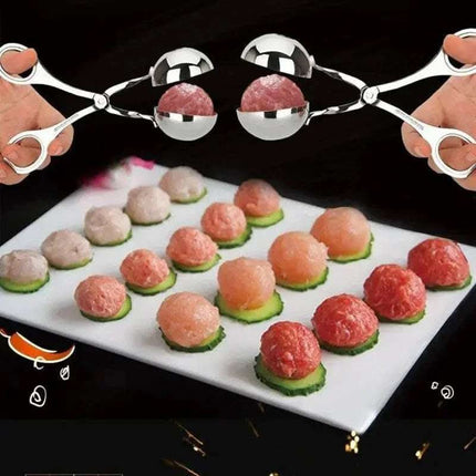 Close-up of metal meatball tongs holding meatballs over a platter of meatballs on cucumber slices.