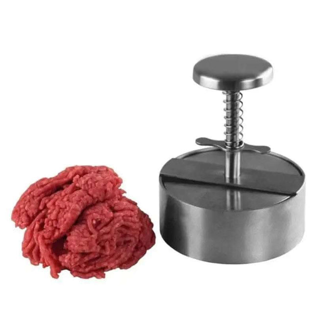A pile of ground beef next to a silver burger press.